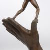 “Jongen op een hand”. Een gepatineerd bronzen kunstwerk.
