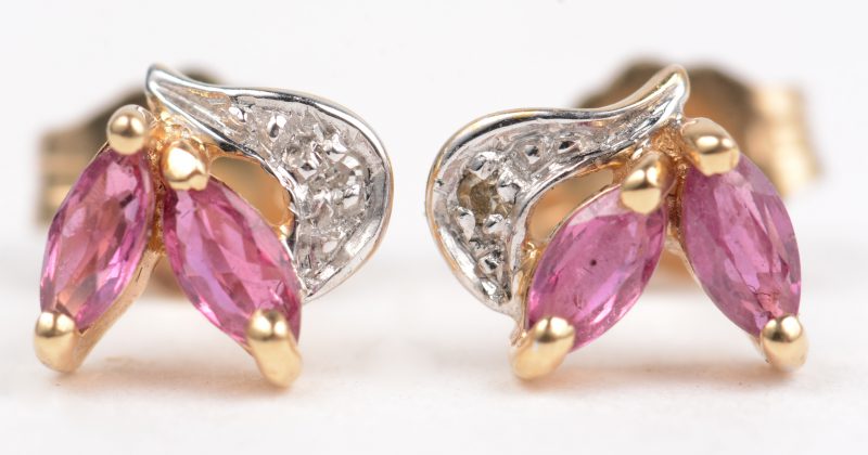 Een paar 18 K wit en geelgouden oorbellen bezet met twee kleine diamantjes en vier robijnen met een gezamenlijk gewicht van +- 0, 20 ct.