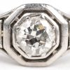 Een 18 K witgouden ring bezet met twee diamantjes oude slijp en een centrale briljant van +- 0,25 ct.