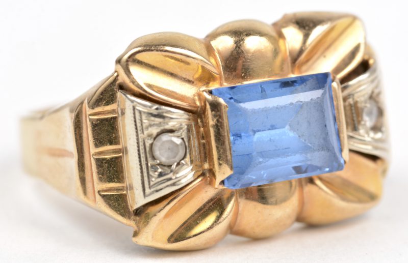 Een 18 K wit en geelgouden ring bezet met een blauwe steen.
