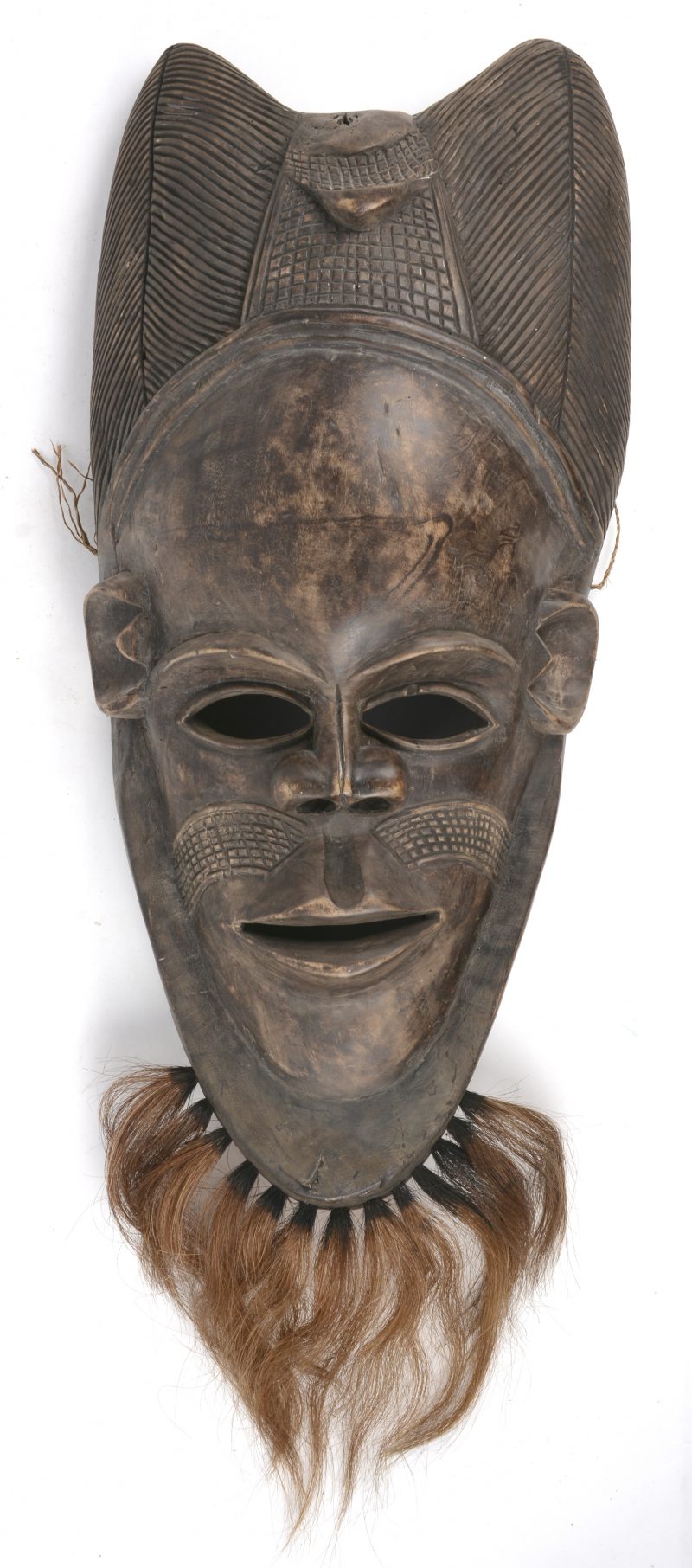 Een groot masker van gesculpteerd hout en versierd met paardenhaar. D.R. Congo.