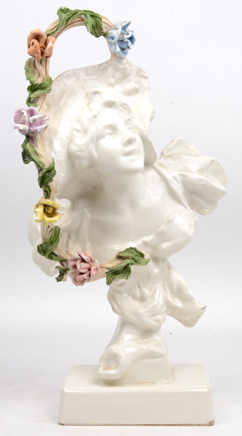 “Vrouw met hoed en bloemen”. Een aardewerken buste. Kleine schilfer van het bovense bloemetje.