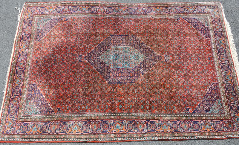 Een handgeknoopt Oosters wollen tapijt.