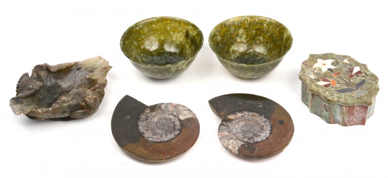 Een lot mineralen, bestaande uit een fossiel, twee jaden kommetjes (één gerestaureerd), een juwelendoosje, ingelegd met parelmoer en een gesculpteerde vide-poche (gerestaureerd) in de vorm van een blad en bloemen.