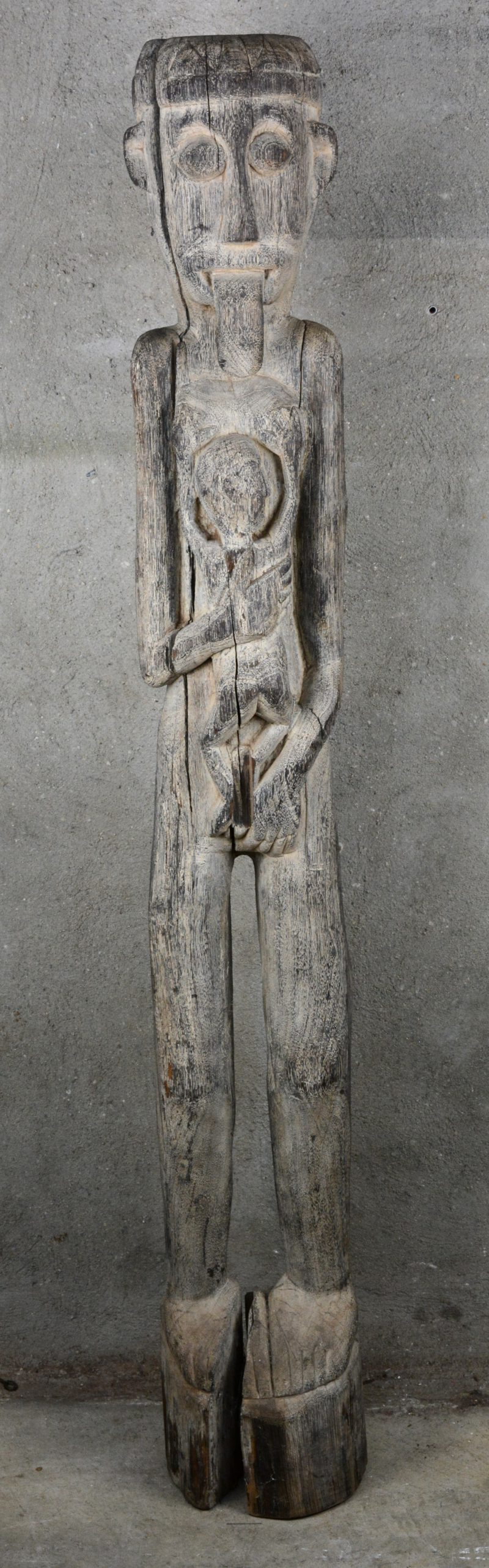 Een mythisch voorouderbeeld of hampatong van gebeeldhouwd hout. Voorstelling van een vrouw met een uitgestoken tong en een kind aan de borst. Borneo, vroeg XXste eeuw.