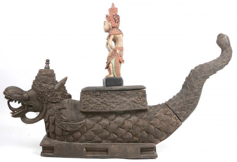 Een gebeeldhouwde houten offerkist in de vorm van een draak met daarop twee polychrome rijstgodinnen. Bali.