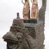 Een gebeeldhouwde houten offerkist in de vorm van een draak met daarop twee polychrome rijstgodinnen. Bali.