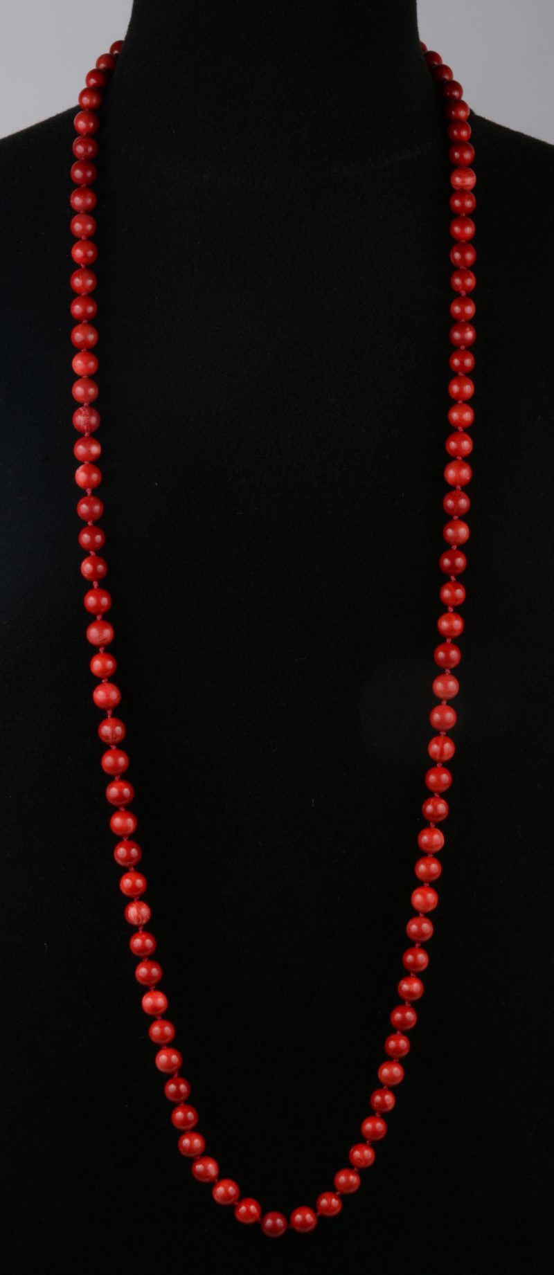 Een rode halssnoer met parels van half edelsteen.