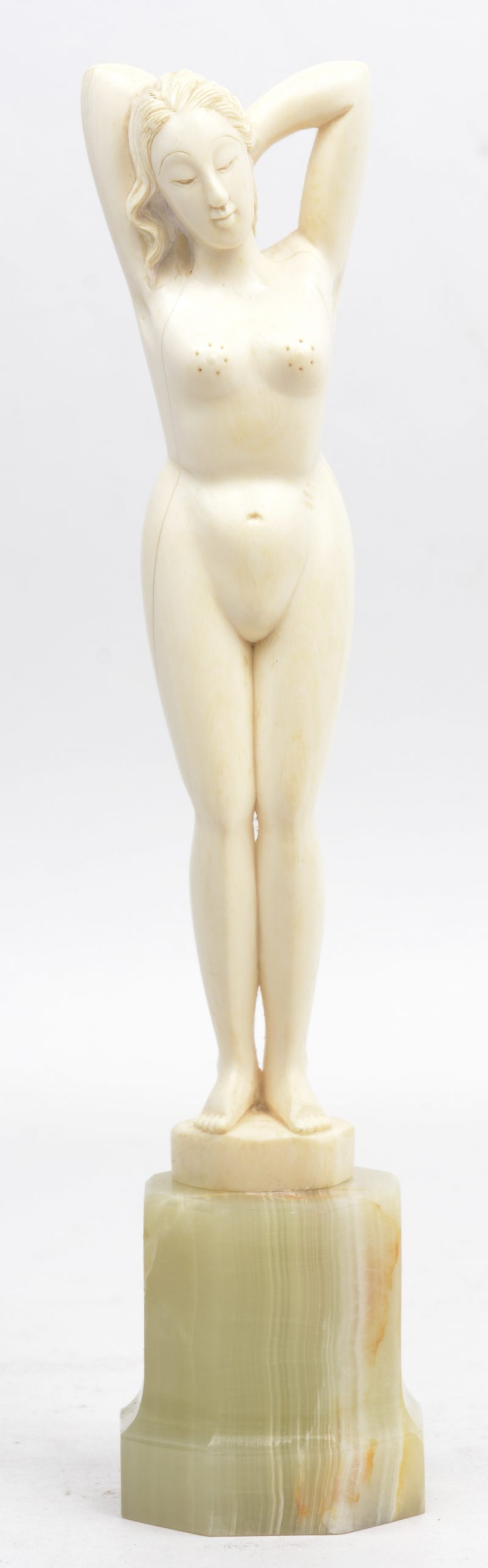 “Vrouwelijk naakt”. Een beeldje van gesneden ivoor. Op onyxen sokkeltje.