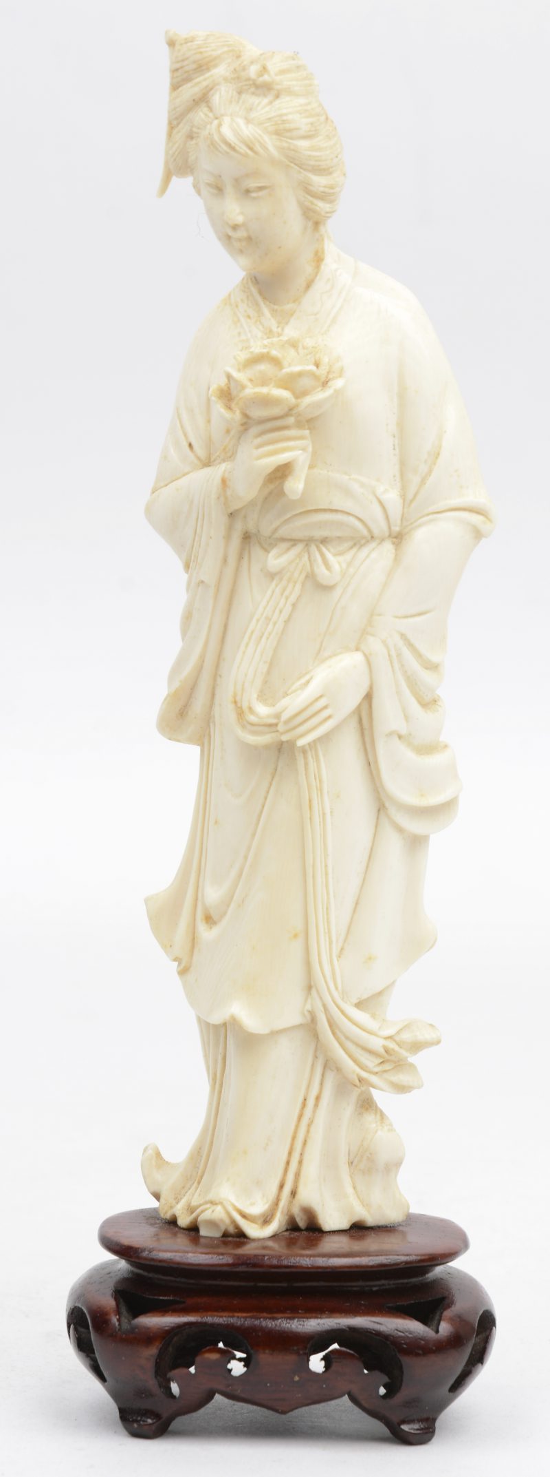 “Dame met pioen”. Een gesneden beeldje van Chinees ivoor op houten sokkeltje.
