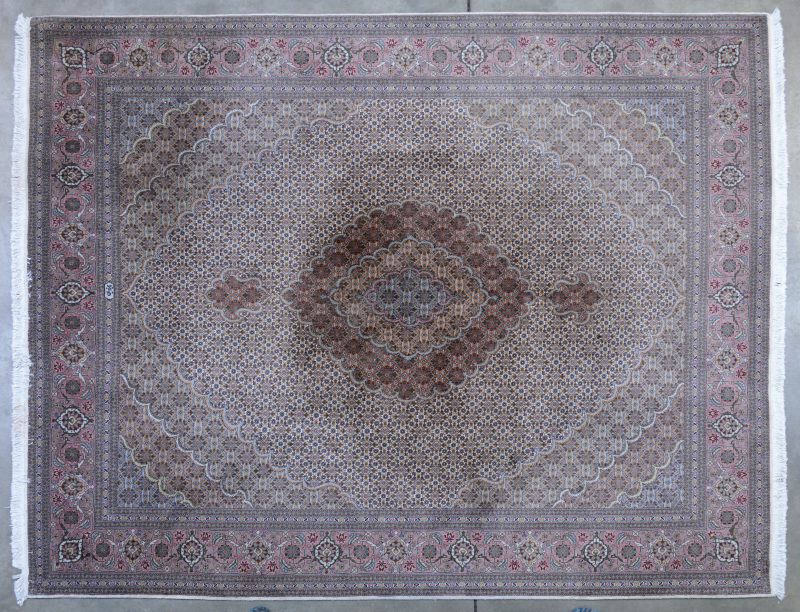 Een handgeknoopt Perzisch wollen tapijt. Gesigneerd.