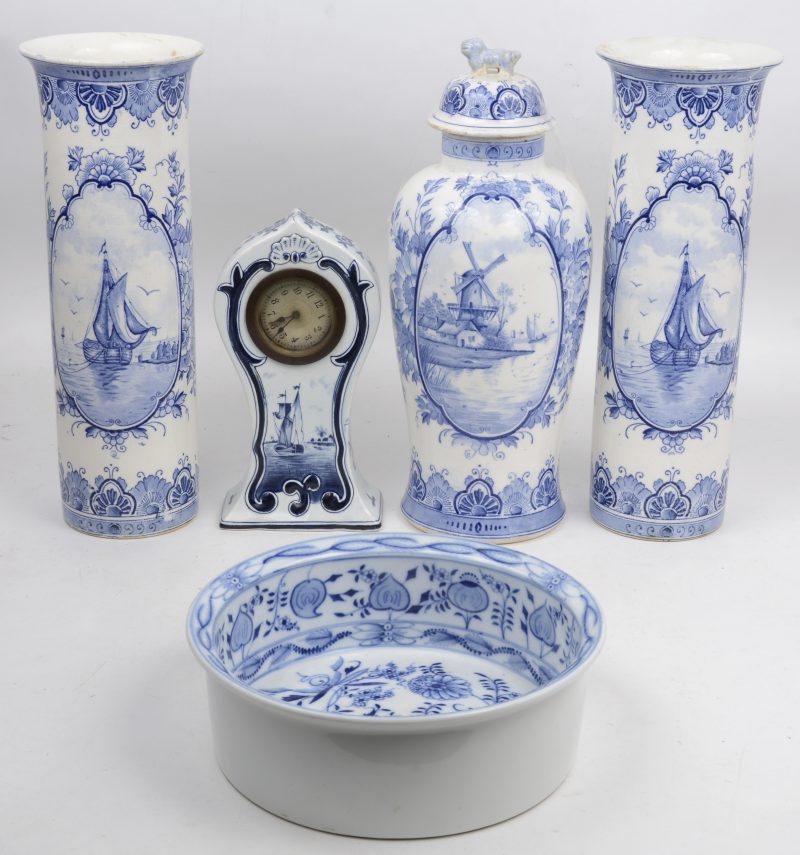 Een lot blauw en wit aardewerk, bestaande uit een driedelig Delfts schouwtelletje, een Delfts klokje en een ronde kom met bloemendecor.