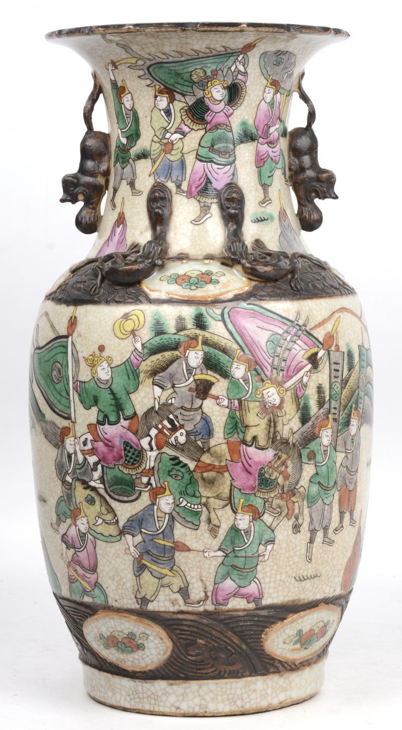 Een balustervaas van Nanking aardewerk met een meerkleurig decor van krijgers en versierd met Fo-honden en draakjes in reliëf.