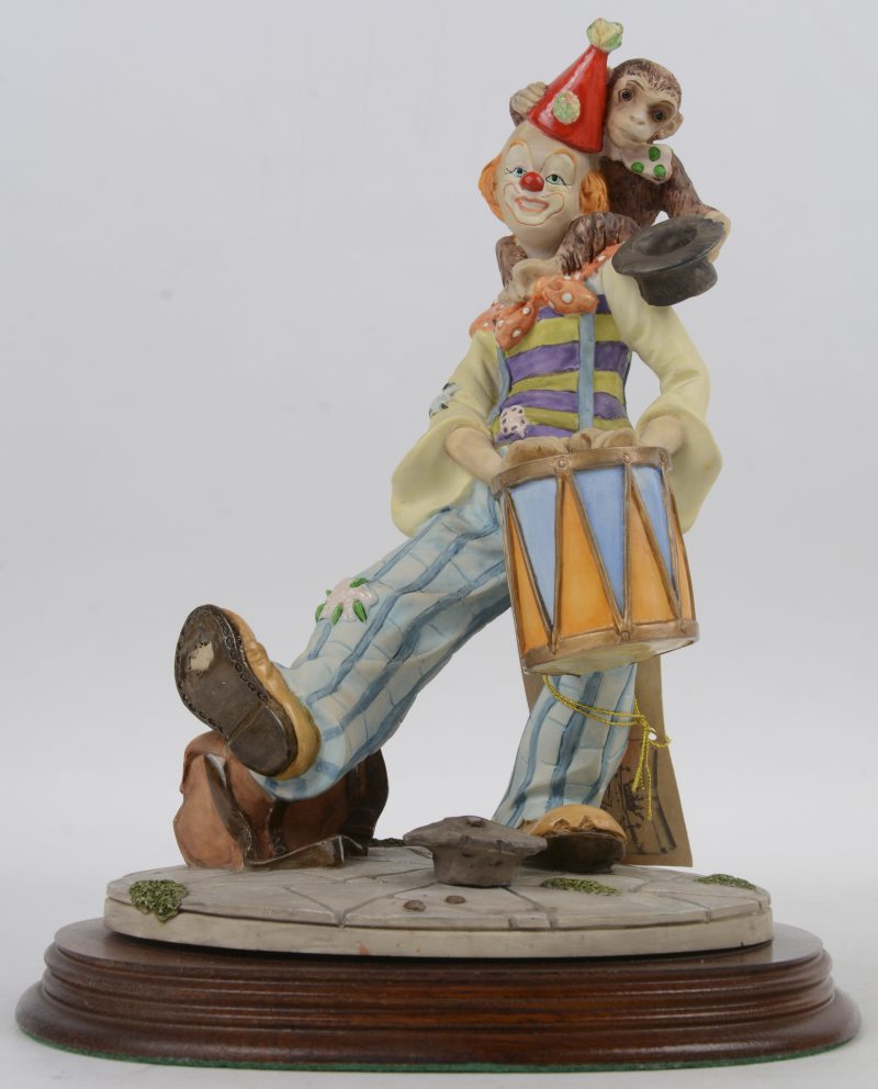 “Straatmuzikant”. Een beeldje van meerkleurig kunsthars op houten voetstuk. Gemerkt en in doos.