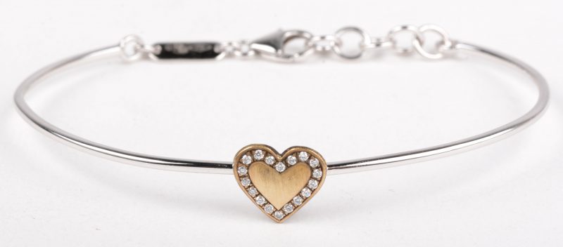 Een 18 K witgouden armband met een geelgoud hartje bezet met kleine diamantjes.