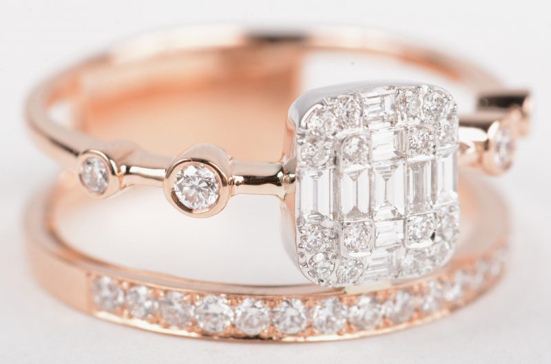 Een 18 K roze gouden ring bezet met briljanten en diamant baguetten met een gezamenlijk gewicht van +- 0,80 ct.