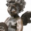 “Engel met cimbalen”. Een bronzen beeld op marmeren sokkel.