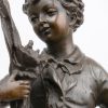 “Scholier met vogelnestje”. Een bronzen beeld naar een werk van Emile Bruchon. Op zwart arduinen sokkel. Met bronsgarantiestempel.