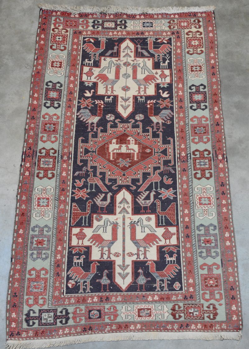 Een handgeknoopt Kaukazisch karpet met decor van vogels.