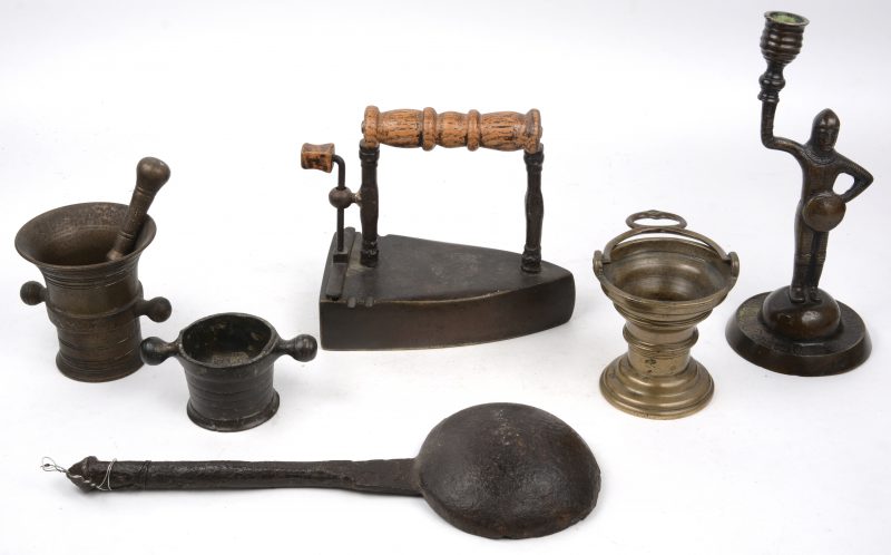Een lot brons en gietijzer, bestaande uit een kandelaar, een strijkijzer, een lepel en drie vijzeltjes.