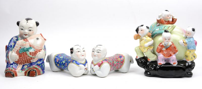 Een lot meerkleurig Chinees porselein, bestaande uit een groepje van vijf kinderen met een perzik, een man met vis en twee liggende kindjes.