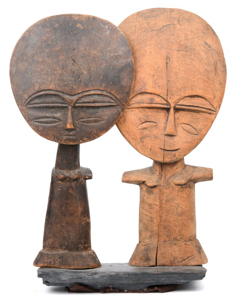 Twee houten vruchtbaarheidspoppen gemonteerd op een stuk leisteen. Ashanti, Ghana.