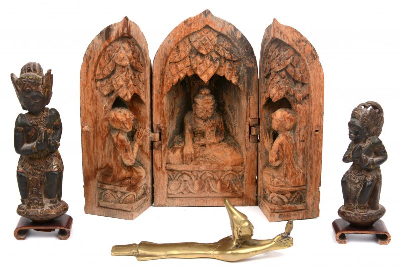 Een huisaltaartje van gesculpteerd hout, twee houten beeldjes van Bali, een biddend personage van messing.