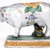 Een koe met boertje van meerkleurig Delfts aardewerk. Onderaan gemerkt. XVIIIe eeuw. Een hoorntje afgebroken.