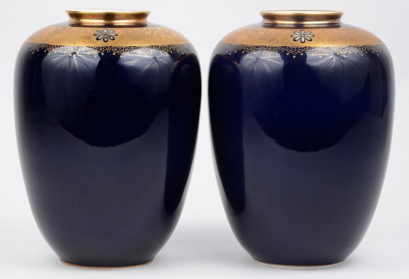 Twee vazen van kobaltblauw porselein met verguld decor. Onderaan gemerkt.