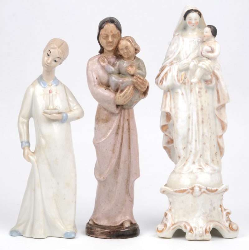 Drie beeldjes, bestaande uit een Madonna met kind van geglazuurd aardewerk, een Madonna met kind van Brussels porselein en een meisje met kaars van Spaans porselein.