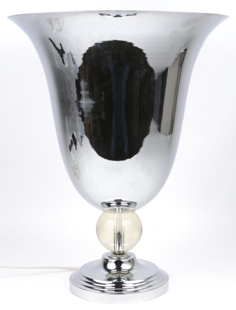 Een verchroomde lamp met glazen bol in de voet.