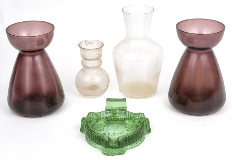 Een lot glaswerk, bestaande uit twee paarse vaasjes, twee verschillende kleurloze vaasjes en een groene asbak van Chien Vert.