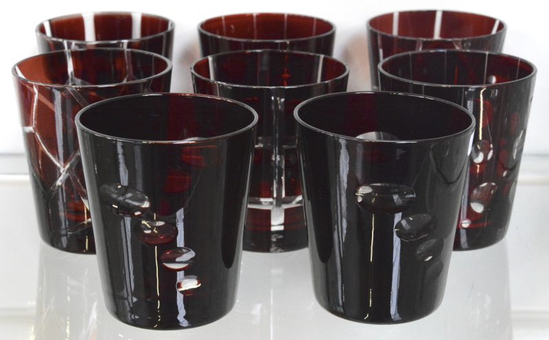 Een reeks van acht glazen van rood gedubbeld kristal in vier modellen. Onderaan gemerkt.