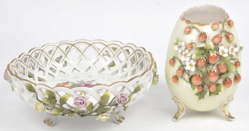 Een opengewerkt porseleinen mandje, versierd met roosjes in reliëf en een eivormig porseleinen vaasje, versierd met aardbeien in reliëf. Beide gemerkt onderaan.