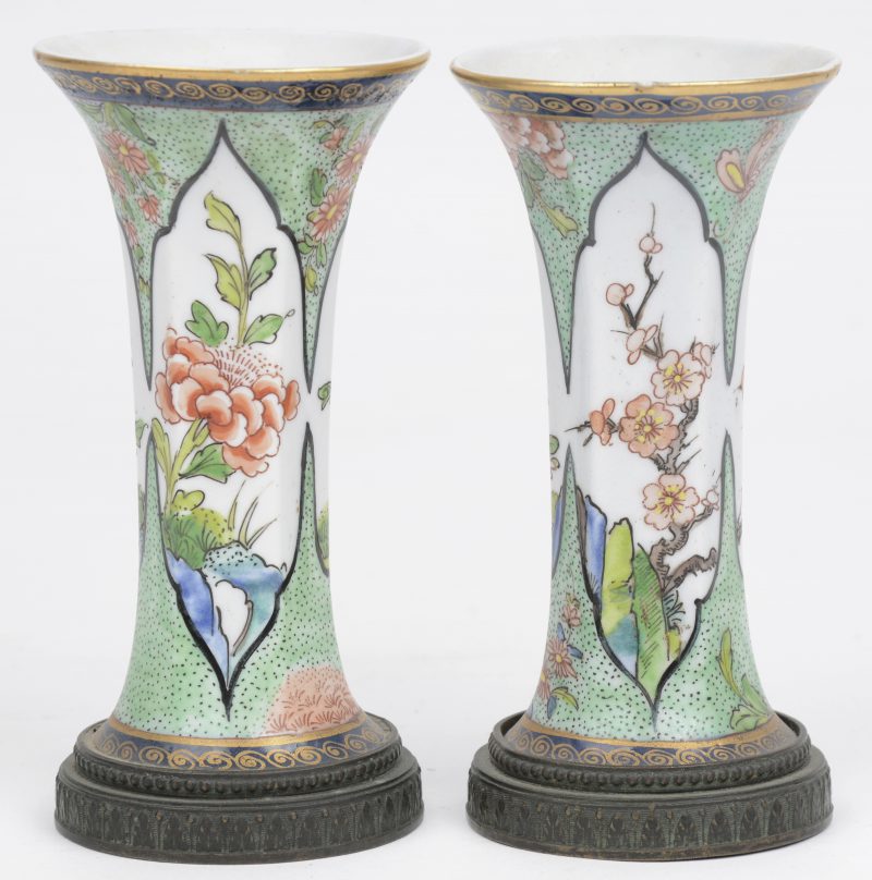 Een paar kleine kraagvaasjes van Chinees porselein, versierd met een decor van bloesems. Met bronzen voet.