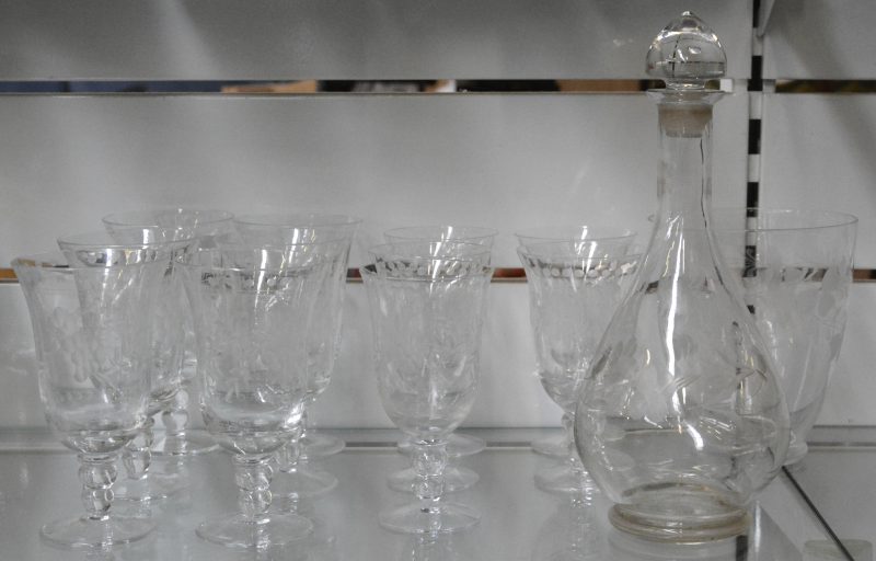 Een reeks van zes grote en vijf kleine kleurloze glazen met geslepen decor. Bijgevoegd een gelijkaardige karaf en ijsemmertje.