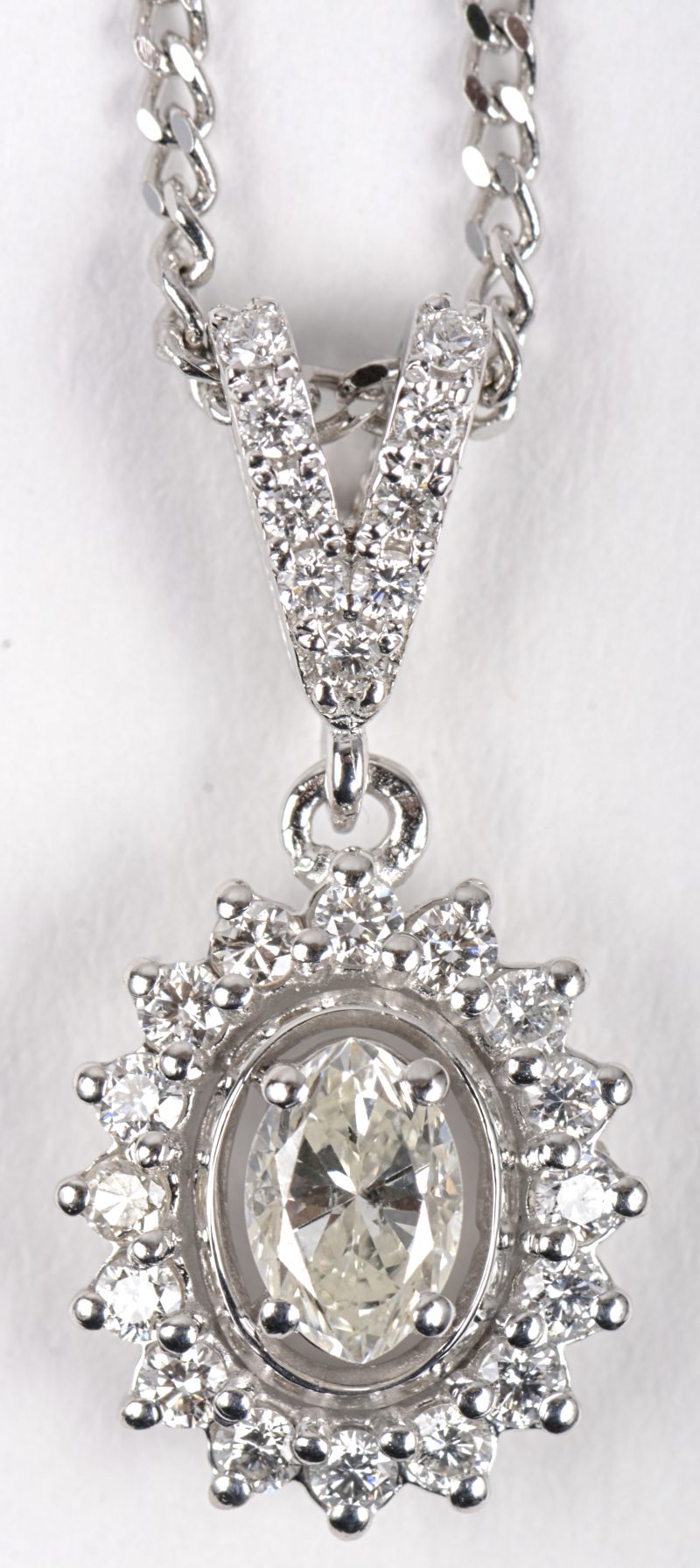 Een 18 K witgouden ketting met hanger bezet met een in markies geslepen diamant van +- 0,32 ct. en briljanten met een gezamenlijk gewicht van +- 0,27 ct.