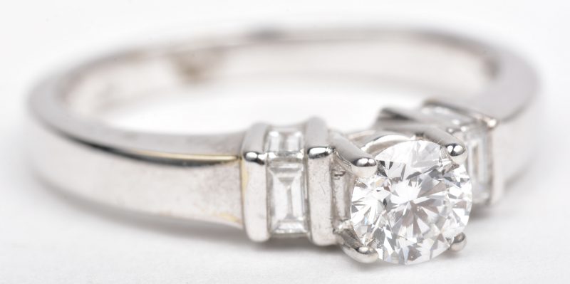 Een 18 K witgouden ring bezet met een solitair briljant van +- 0,40 ct. FVVS1. en diamant baguetten met een gezamenlijk gewicht van +- 0,24 ct.