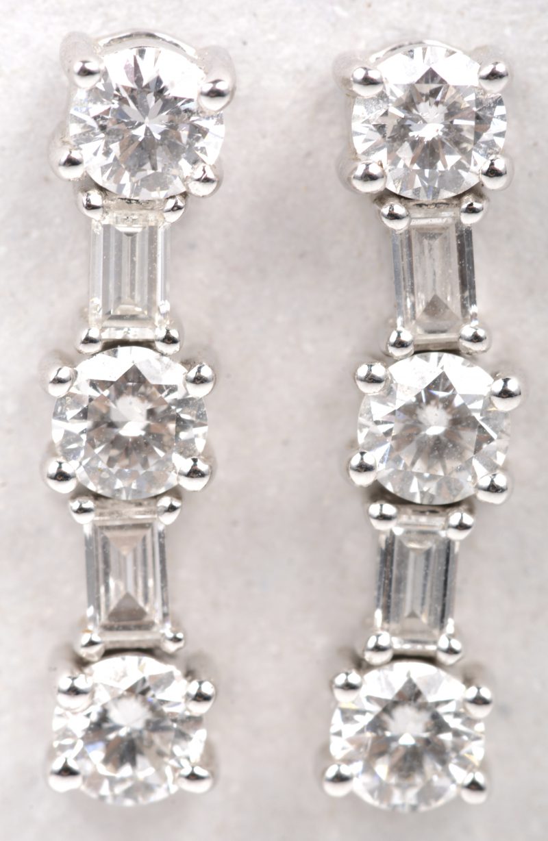 Een paar 18 K witgouden oorbellen bezet met briljanten en diamant baguetten met een  gezamenlijk gewicht van +- 1,22 ct.