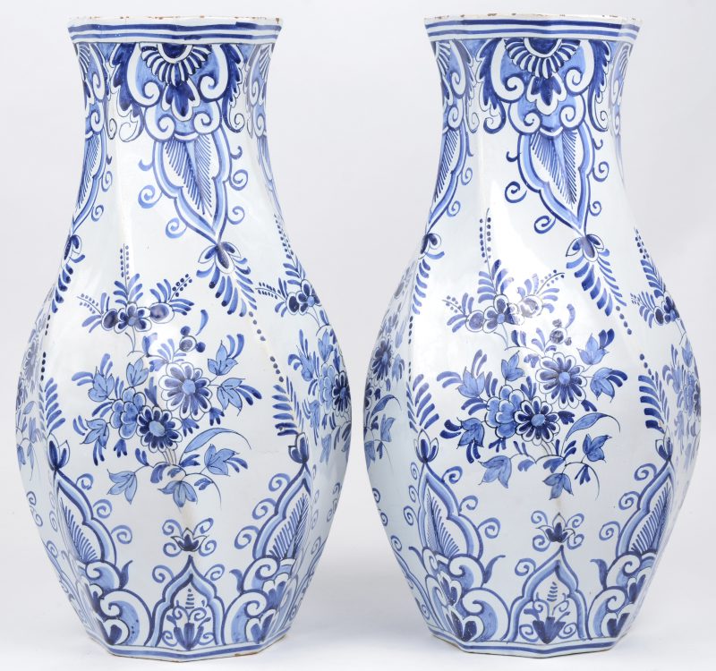 Een paar getorste vazen in delfts blauw-wit porselein met een bloemen decor. Onderaan gemerkt.