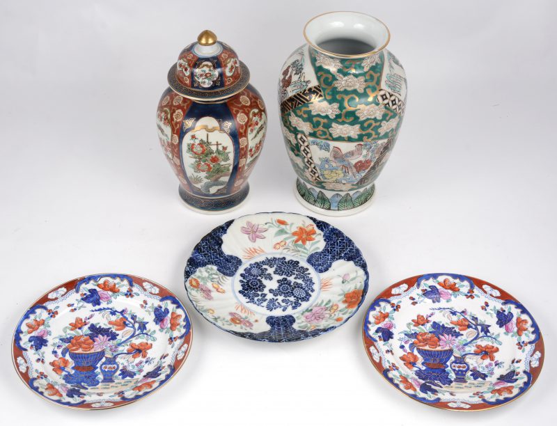 Een lot Chinees en Japans porselein bestaande uit drie borden (Ø 22 cm) en twee Imarivazen waarvan een deksel.