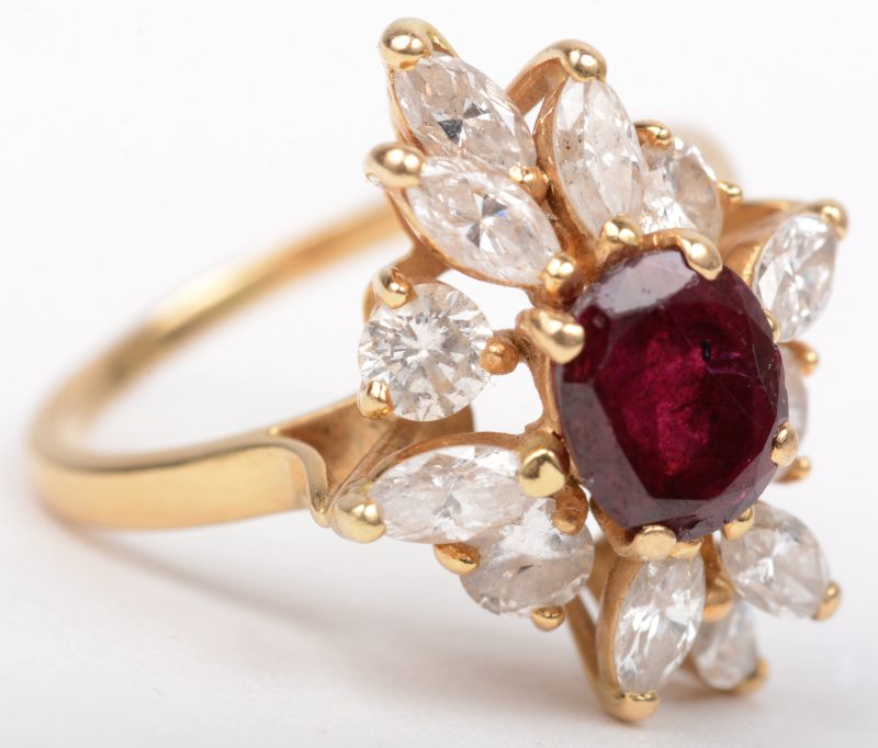 Een 18 K geelgouden ring bezet met diamanten in markies geslepen en briljanten met een gezamenlijk gewicht van +- 1 ct. en een centrale robijn van +- 0,75 ct.