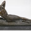 “Liggende vrouw”. Een gepatineerd bronzen beeld in art deco-stijl naar een werk van Agathon Léonard. Op zwart marmeren sokkel.