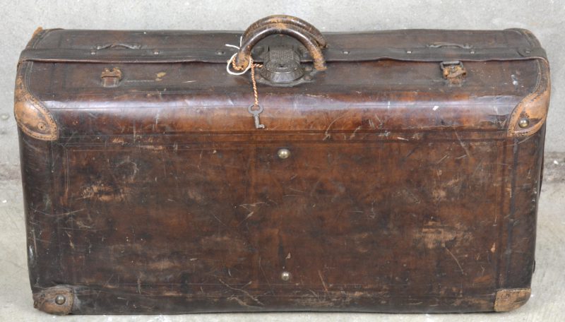Een antieke lederen reiskoffer. Met sleuteltje.