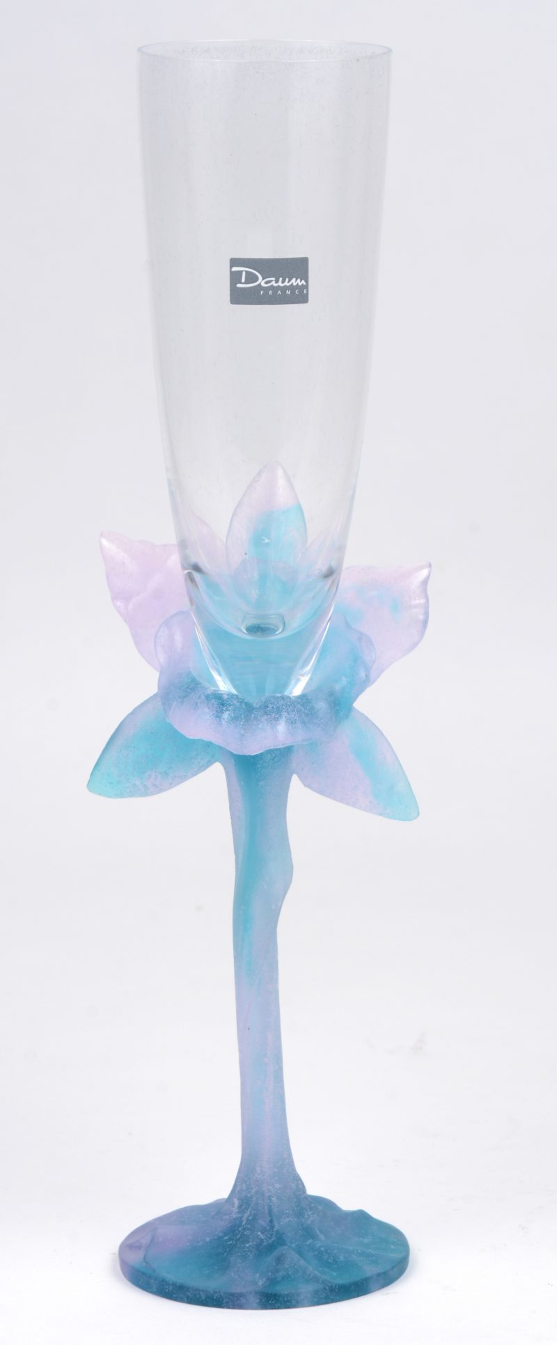 Een kristallen fluitglas op gekleurde bloemvormige voet. Gemerkt en in originele doos.