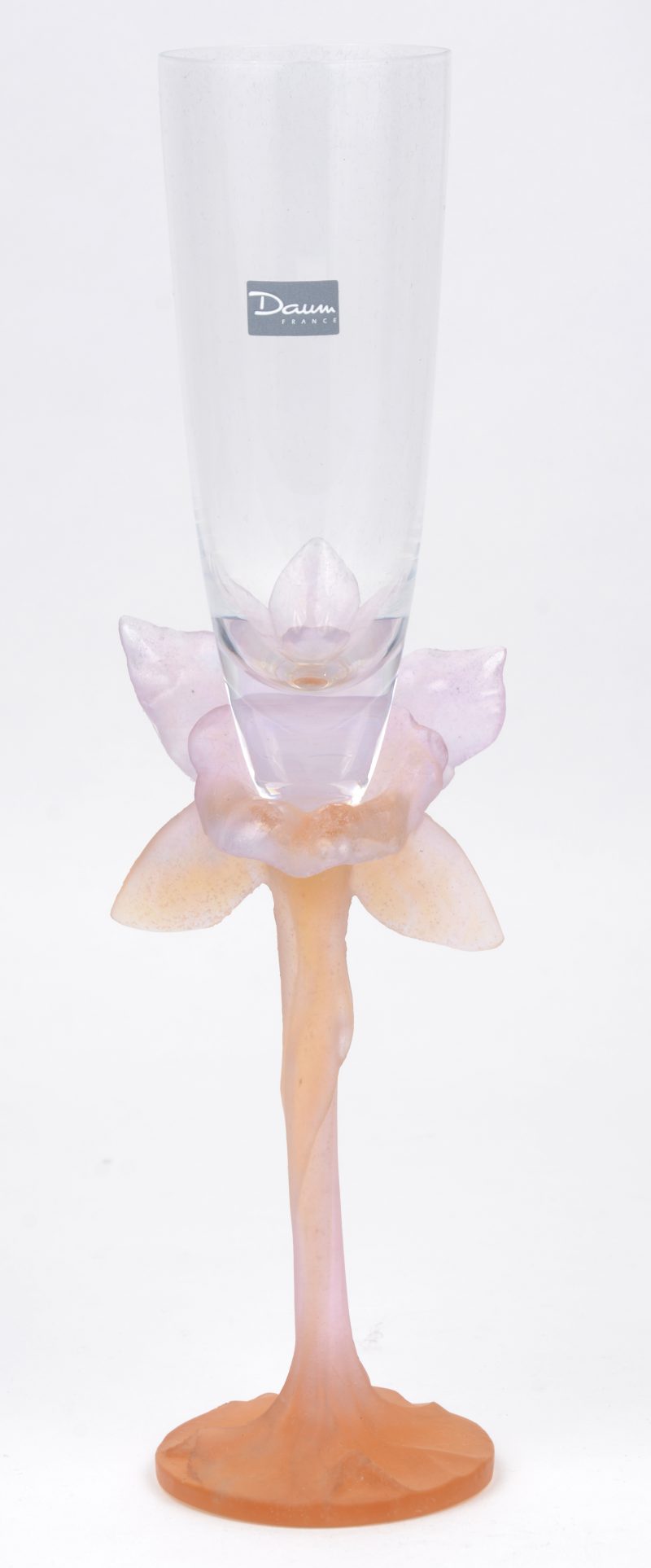 Een kristallen fluitglas op gekleurde bloemvormige voet. Gemerkt en in originele doos.