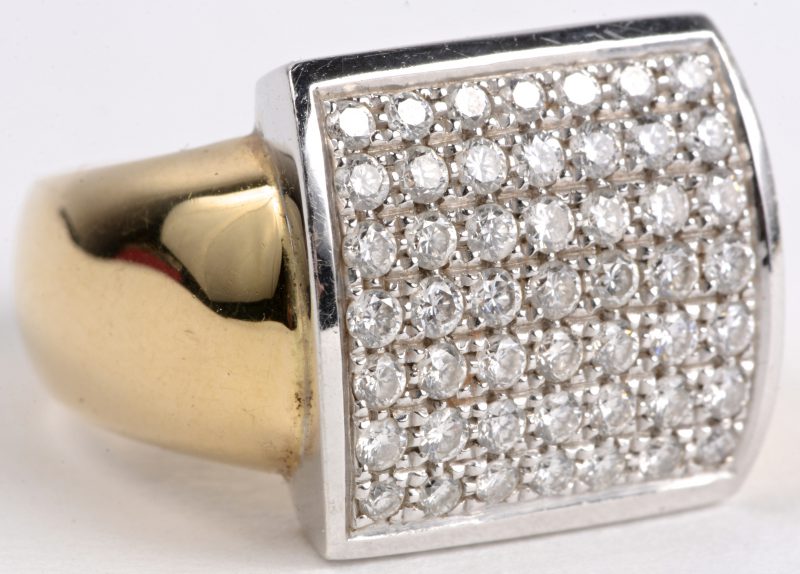Een 18 karaats wit en geel gouden ring bezet met diamanten met een gezamenlijk gewicht van ± 0,90 ct.