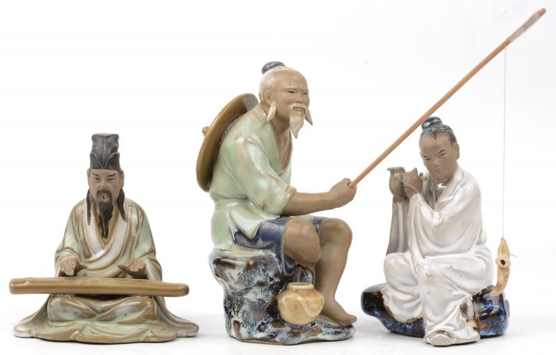 Een lot van drie geglazuurd aardewerken beeldjes, waarbij één met koto, één met fluit en een visser. Japans werk.