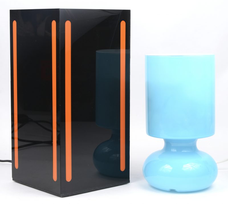 Twee designlampen, waarbij één van blauw glas en één van zwart en ornaje plexiglas.