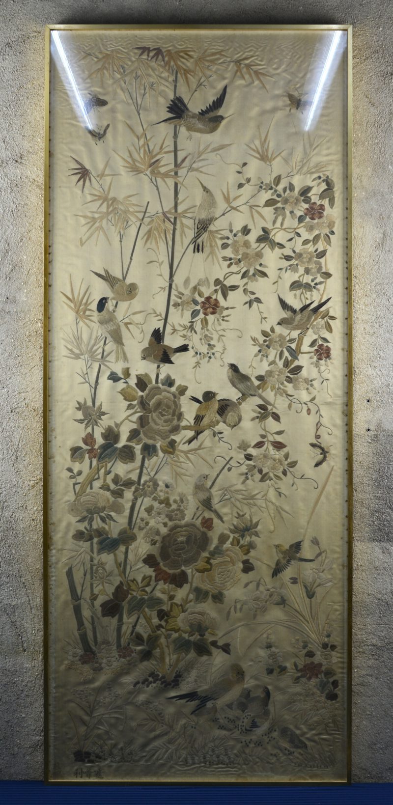 Een chinees borduurwerk met vogels, vlinders en bloemen op zijde. Gesigneerd links onderaan.